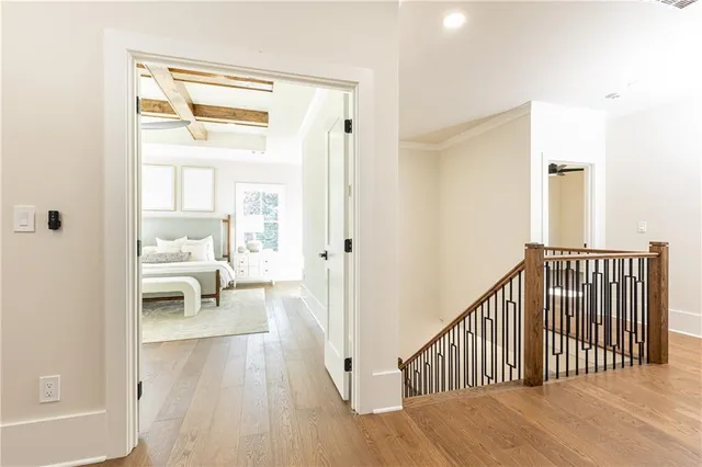 a view of a hallway with wooden floor and a living room