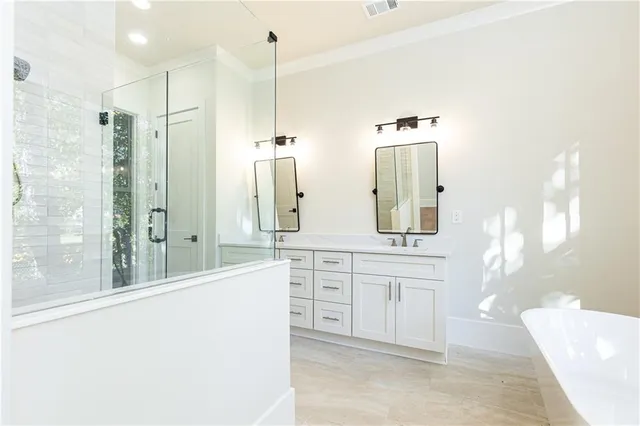 a spacious bathroom with a double vanity sink a mirror and a shower