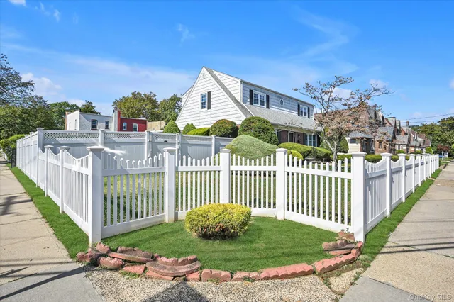 a view of a brick house with a small yard and plants