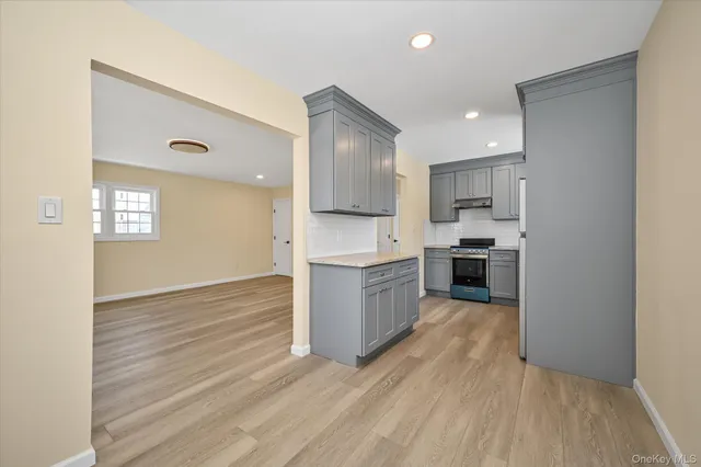 a kitchen with stainless steel appliances granite countertop a stove a sink and a refrigerator