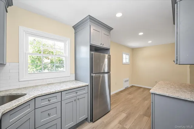 a kitchen with a refrigerator sink and cabinets