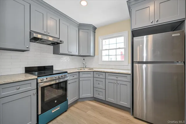 a kitchen with cabinets stainless steel appliances and a window