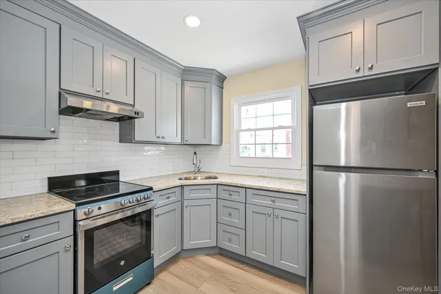 a kitchen with a refrigerator sink and cabinets