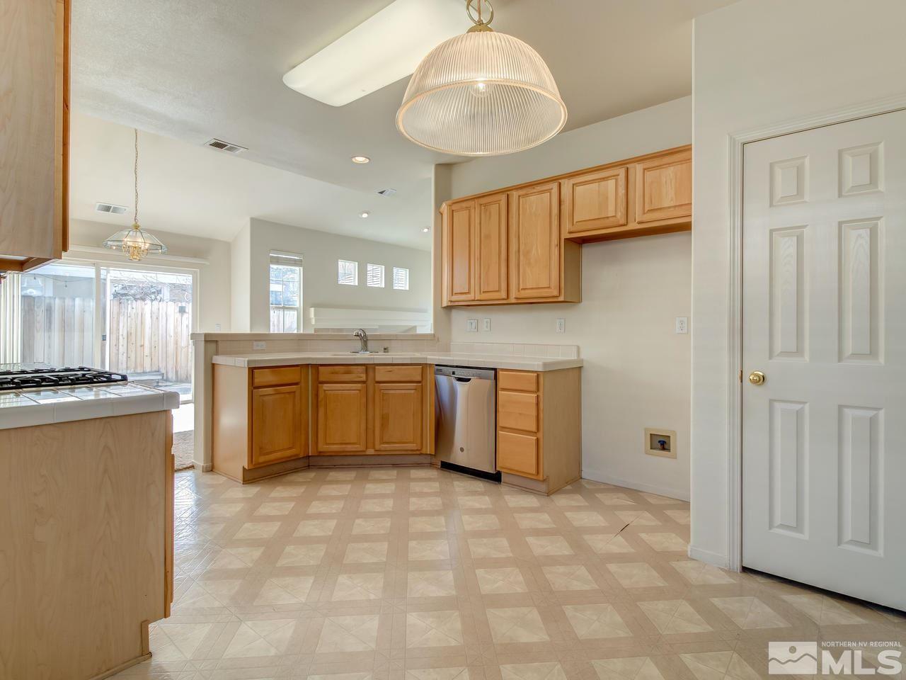 9647 Truckee Meadows Place Reno, NV 89521 - Photo 11 of 25 a kitchen with stainless steel appliances granite countertop a stove sink and cabinets