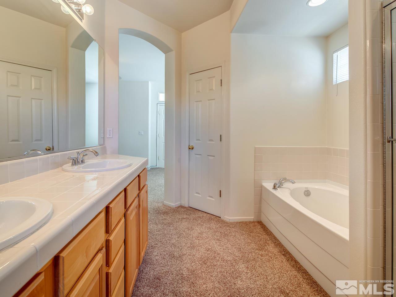 9647 Truckee Meadows Place Reno, NV 89521 - Photo 13 of 25 a spacious bathroom with a tub sink and mirror