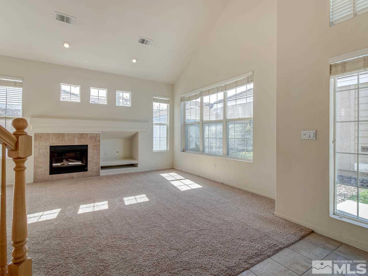 9647 Truckee Meadows Place Reno, NV 89521 - Photo 4 of 25 a view of an empty room with a fireplace and a window