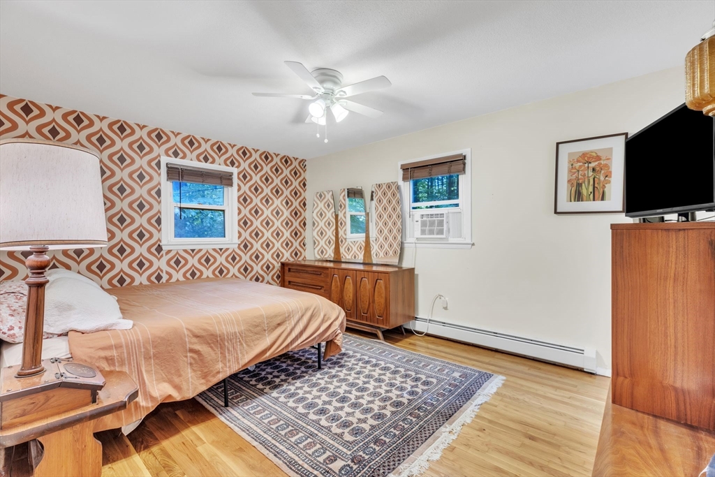 4 Colonial Road Sutton, MA 01590 - Photo 20 of 38 a bedroom with a bed and a chandelier