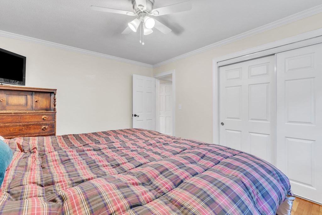 4 Colonial Road Sutton, MA 01590 - Photo 22 of 38 a bedroom with a bed and a flat tv screen on dresser