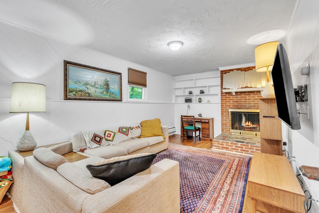 4 Colonial Road Sutton, MA 01590 - Photo 28 of 38 a living room with fireplace furniture and a flat screen tv