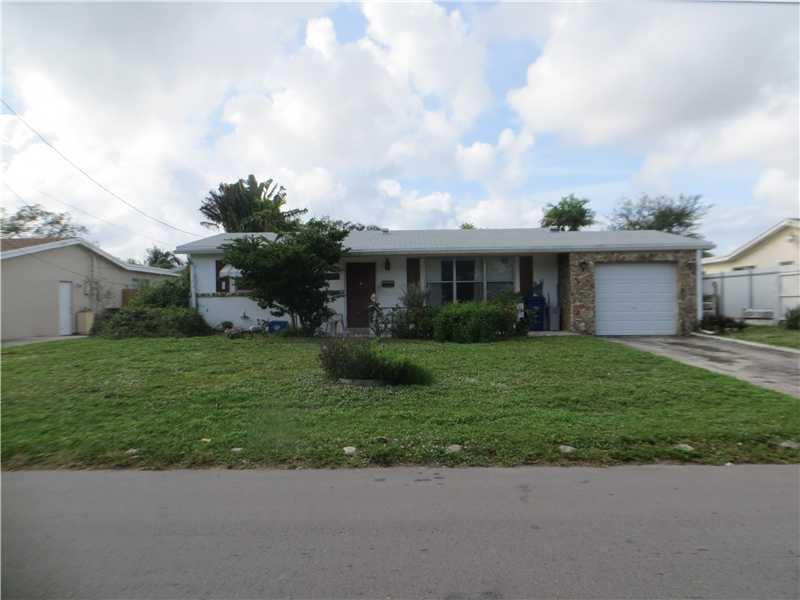 a front view of a house with a garden and yard