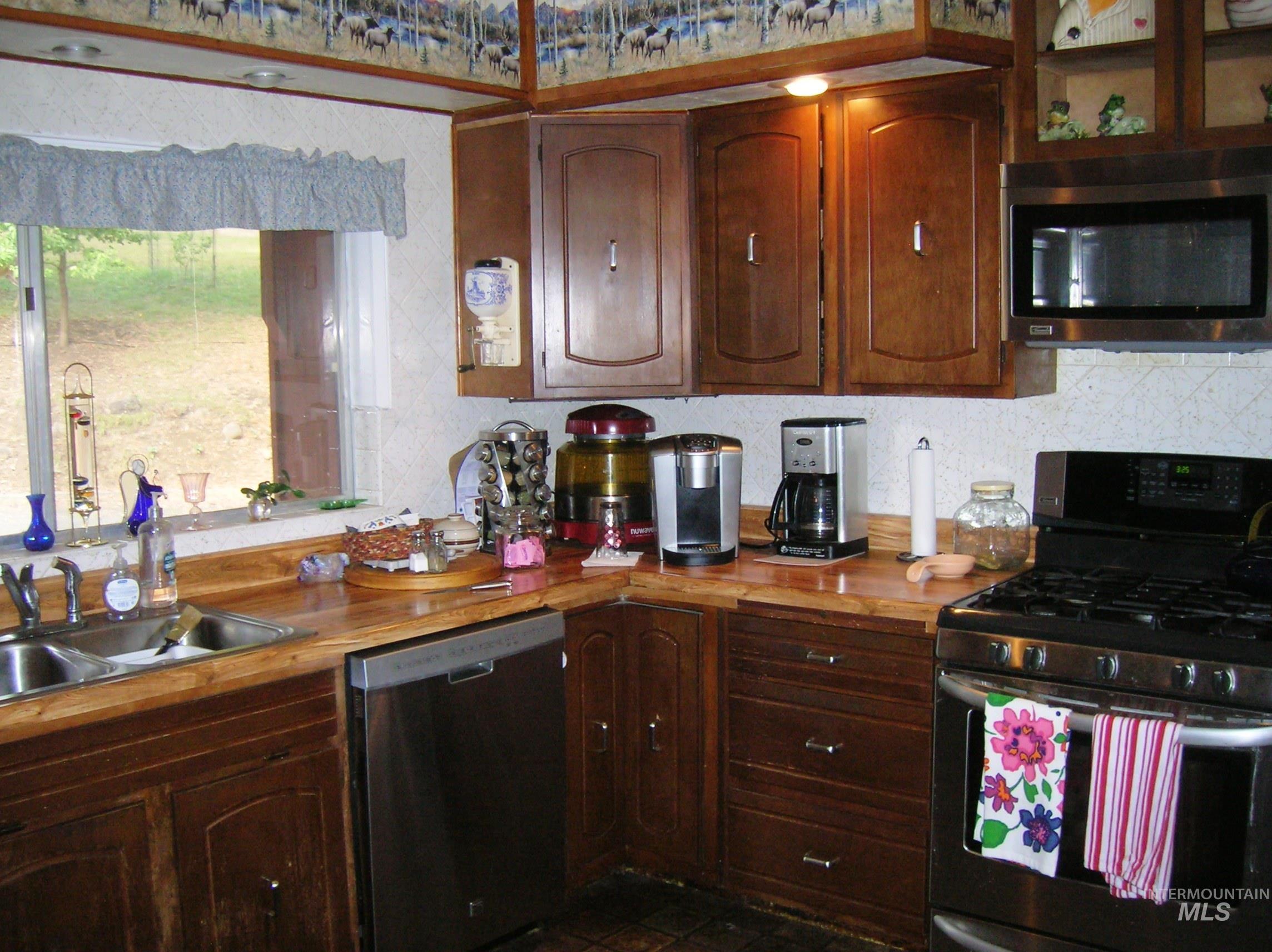 307 Locust Road Kamiah, ID 83536 - Photo 29 of 50 Wood-finish countertops, stainless steel dual basin sink, stainless steel dishwasher, stainless steel oven, and wood cabinetry