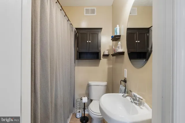 a bathroom with a sink a toilet and mirror