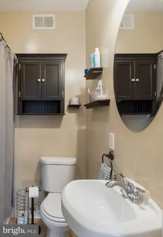 a bathroom with a toilet a sink and mirror