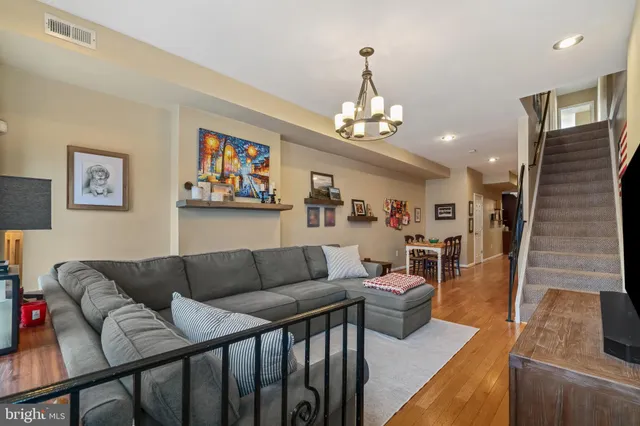 a living room with furniture a dining table and a chandelier