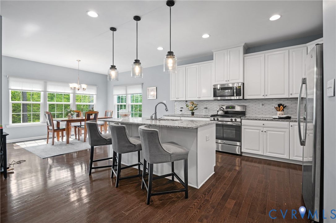 1012 Water Beech Road Midlothian, VA 23114 - Photo 15 of 47 a kitchen with stainless steel appliances granite countertop a stove a sink dishwasher a refrigerator with white cabinets and wooden floor