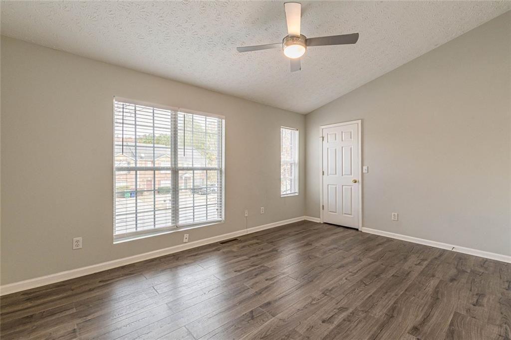 3151 Kingswood Glen Decatur, GA 30034 - Photo 21 of 38 an empty room with wooden floor chandelier fan and windows