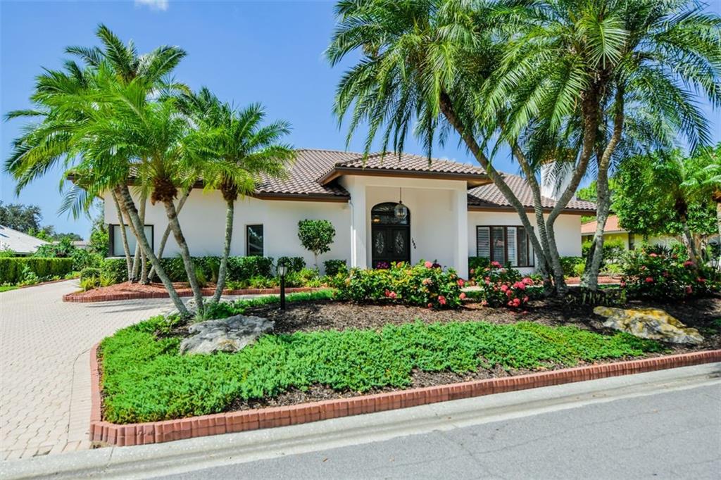 Fantastic Curb Appeal with lush palms and circle + side entry drive.
