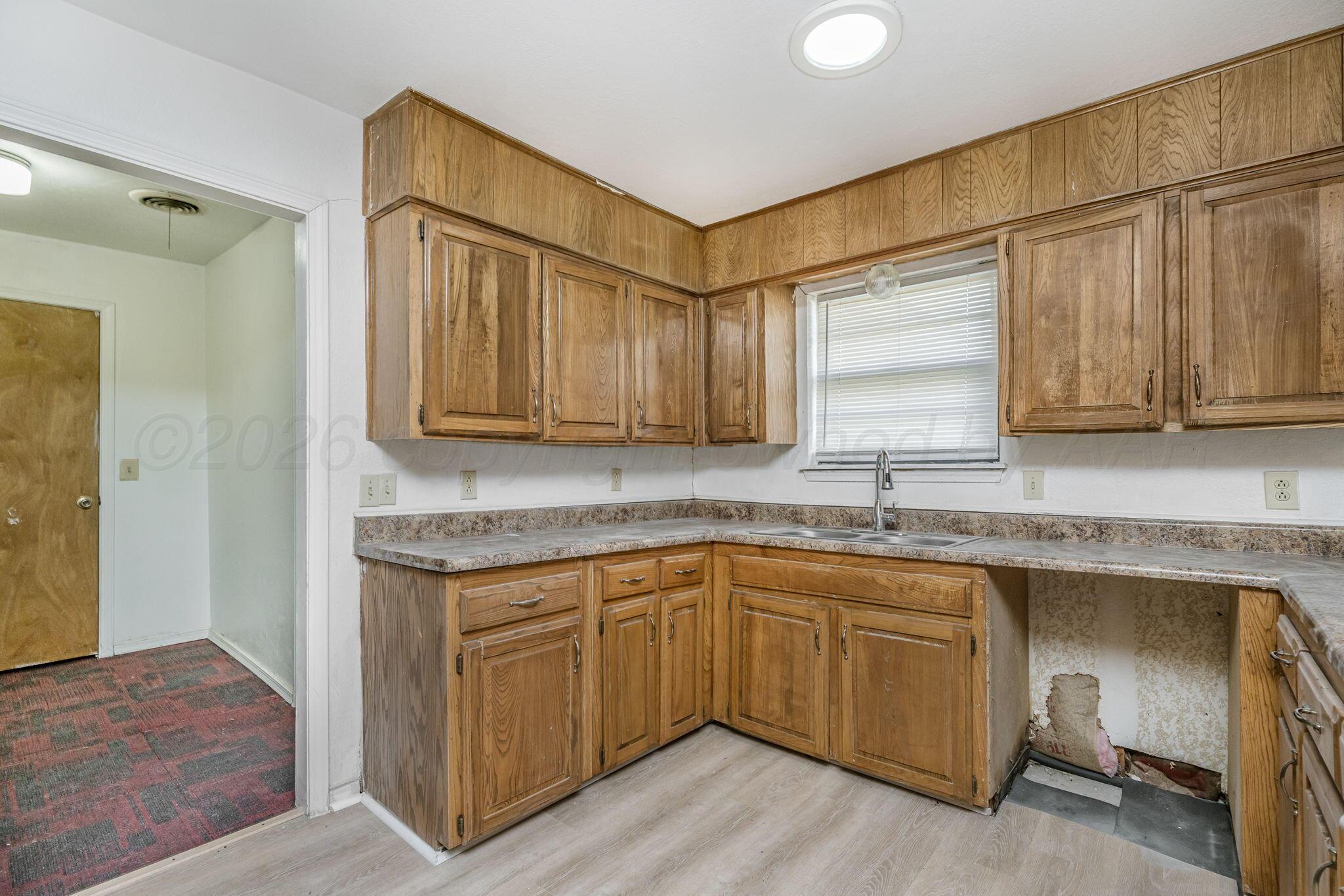 3103 Southwest 27th Avenue Amarillo, TX 79109 - Photo 11 of 21 a kitchen with a sink cabinets and wooden floor