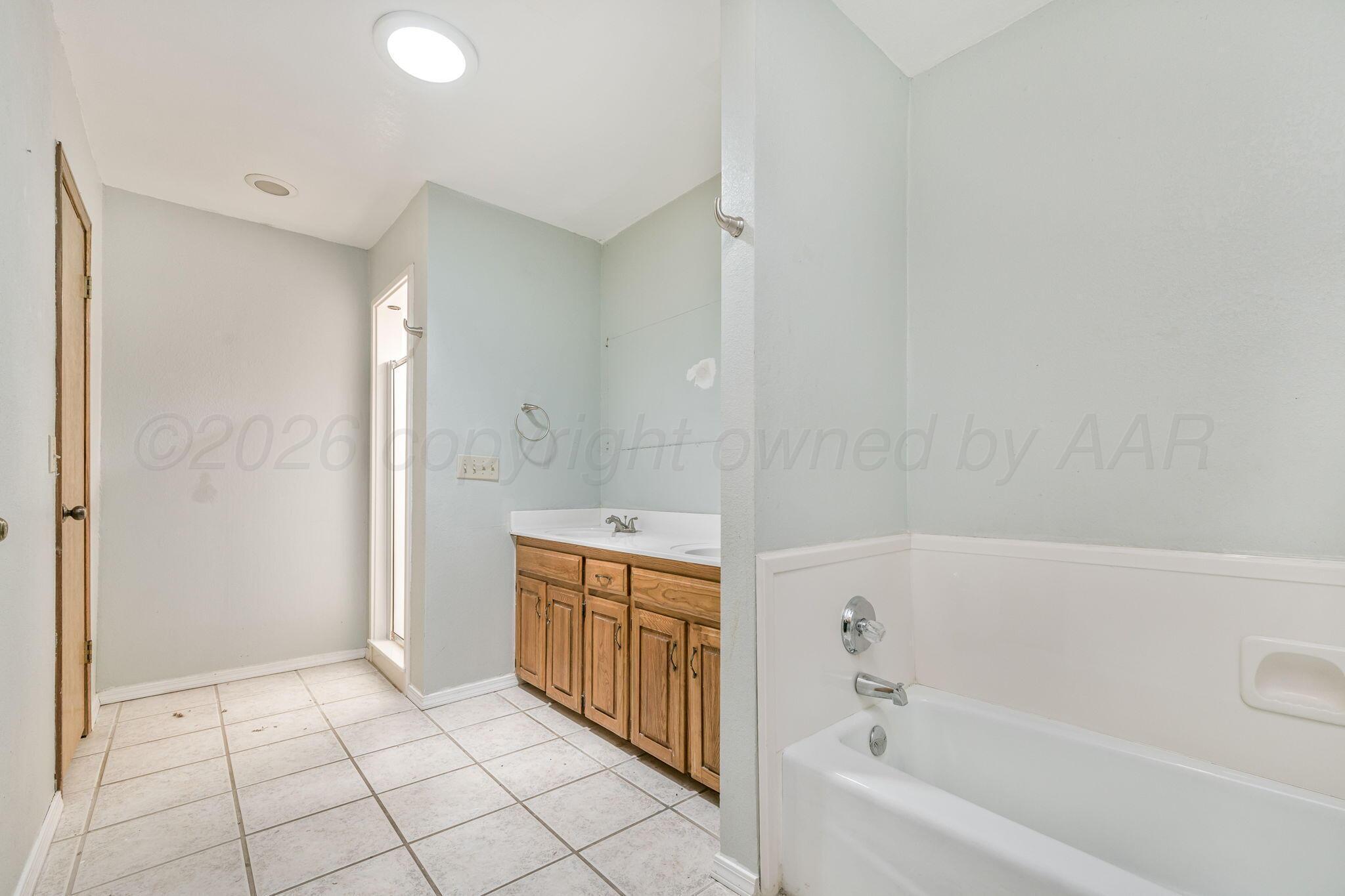 3103 Southwest 27th Avenue Amarillo, TX 79109 - Photo 14 of 21 a bathroom with a bathtub and a shower