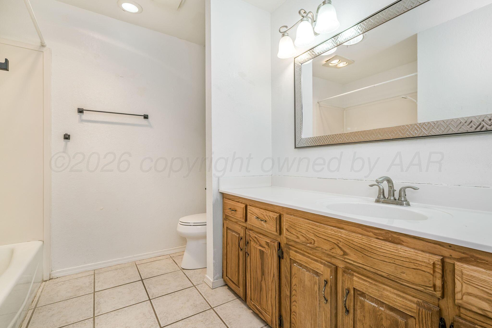 3103 Southwest 27th Avenue Amarillo, TX 79109 - Photo 16 of 21 a bathroom with a granite countertop sink a toilet and a mirror