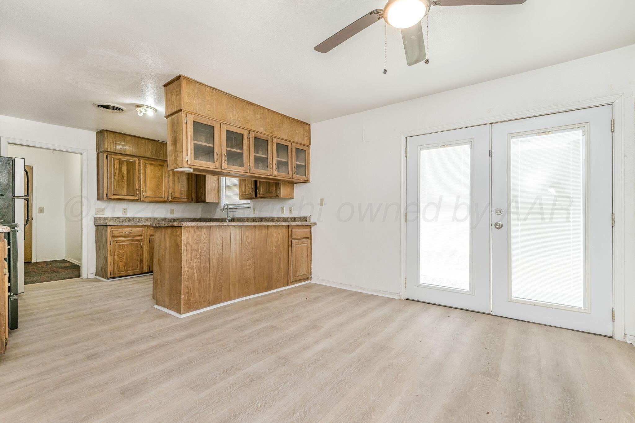 3103 Southwest 27th Avenue Amarillo, TX 79109 - Photo 8 of 21 a view of a kitchen with a sink and dishwasher cabinets with wooden floor