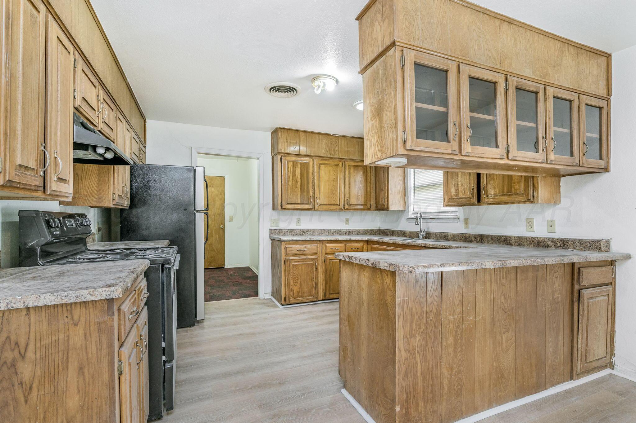3103 Southwest 27th Avenue Amarillo, TX 79109 - Photo 9 of 21 a kitchen with stainless steel appliances granite countertop a sink stove and refrigerator