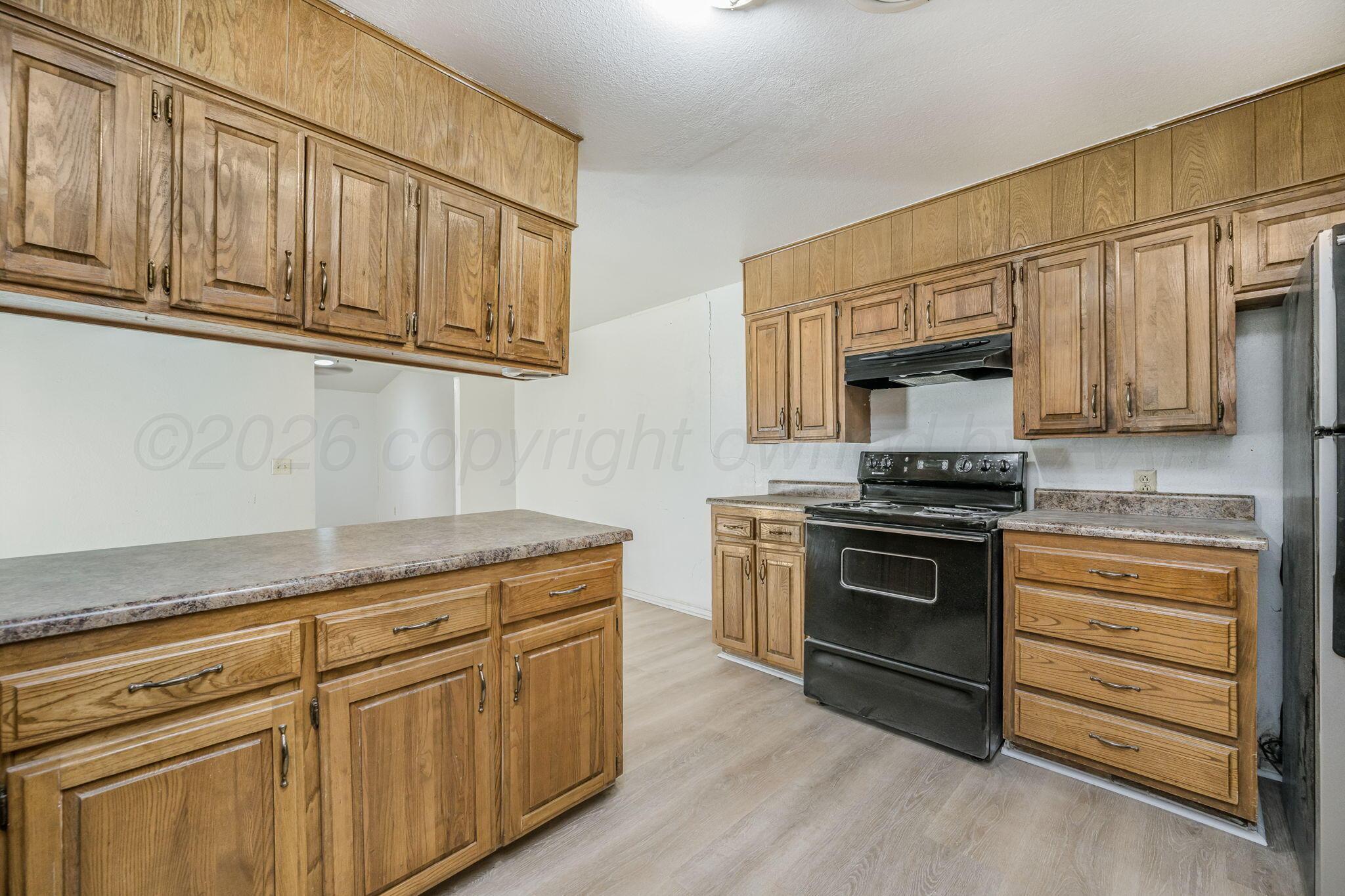 3103 Southwest 27th Avenue Amarillo, TX 79109 - Photo 10 of 21 a kitchen with granite countertop cabinets stainless steel appliances and wooden floor