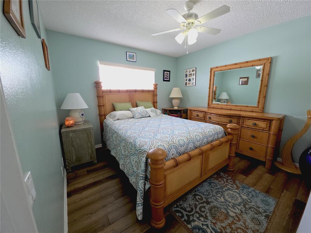 10085 Blackburn Street Spring Hill, FL 34608 - Photo 17 of 25 a bedroom with a bed and dresser with mirror