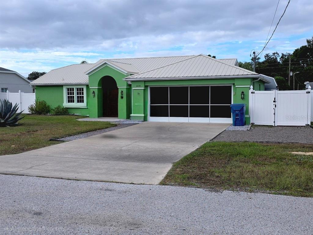 10085 Blackburn Street Spring Hill, FL 34608 - Photo 3 of 25 a front view of a house with a yard and a garage