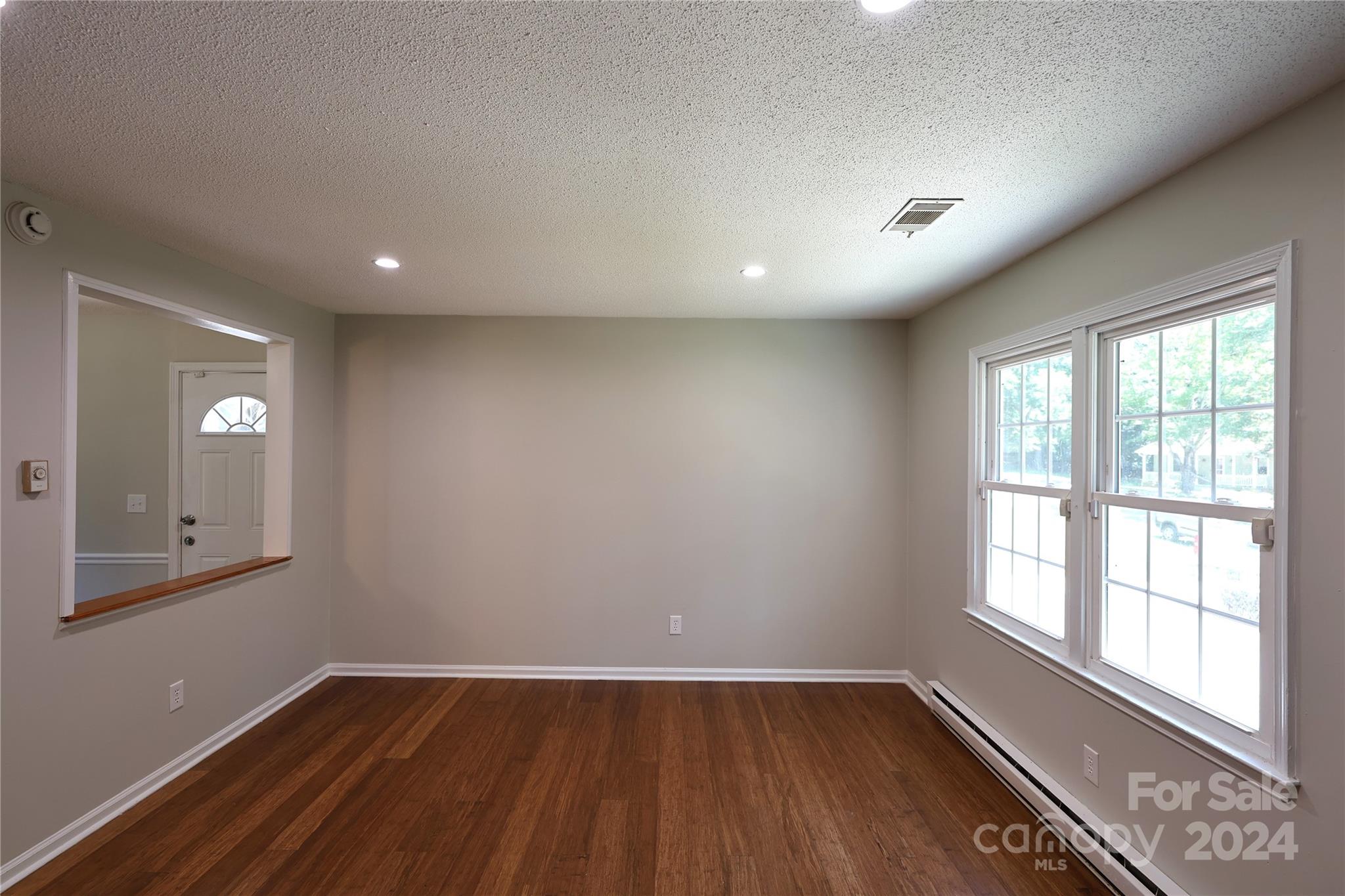 6131 Trotters Ridge Road Charlotte, NC 28227 - Photo 4 of 29 an empty room with wooden floor and windows