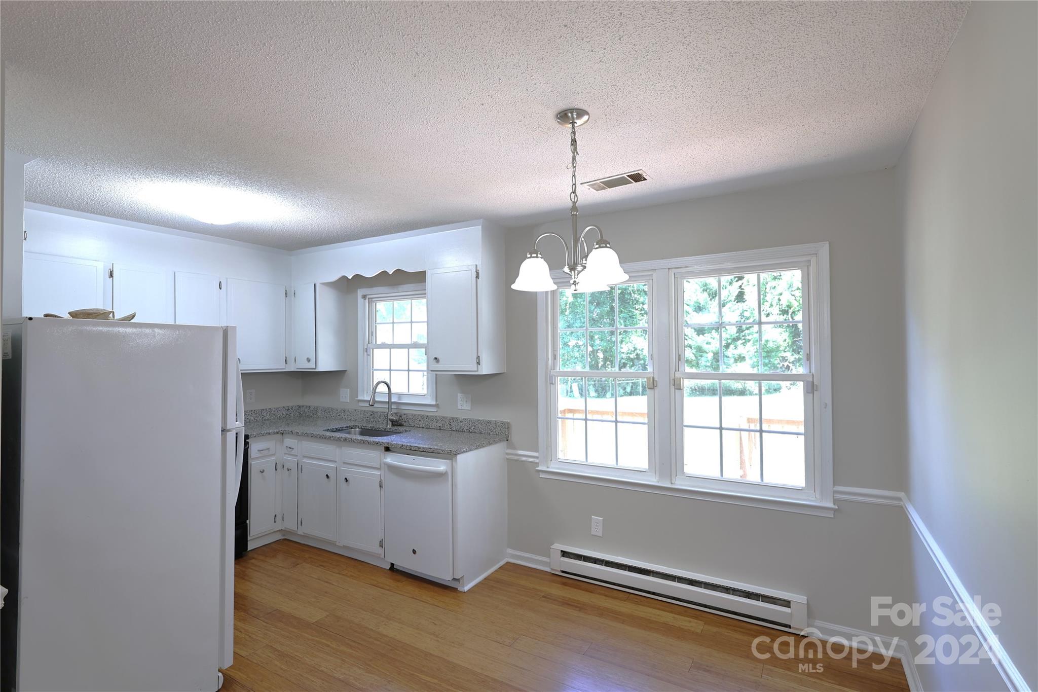 6131 Trotters Ridge Road Charlotte, NC 28227 - Photo 6 of 29 a kitchen with stainless steel appliances granite countertop a refrigerator a sink dishwasher a stove and white cabinets with wooden floor
