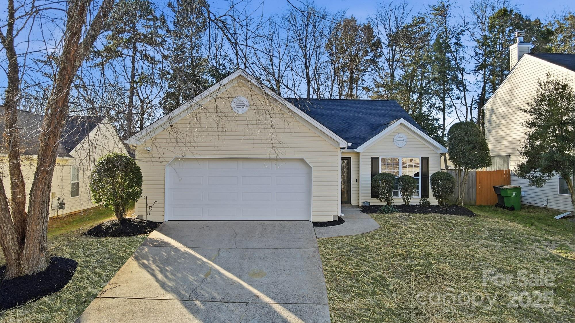 a view of a white house with a yard and garage