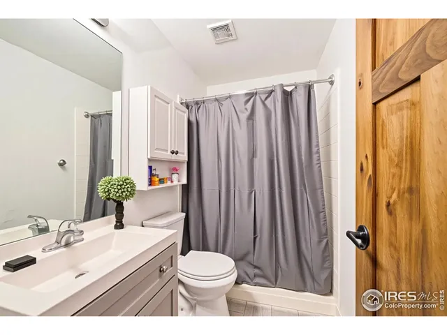 a bathroom with a sink a toilet and shower curtain