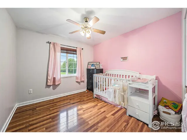 a view of a bedroom with wooden floor