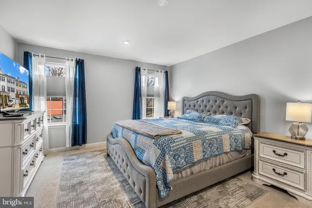 a bedroom with a bed and a flat tv screen on the dresser