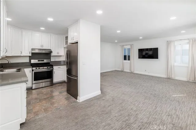 a view of kitchen with refrigerator stove microwave and cabinets