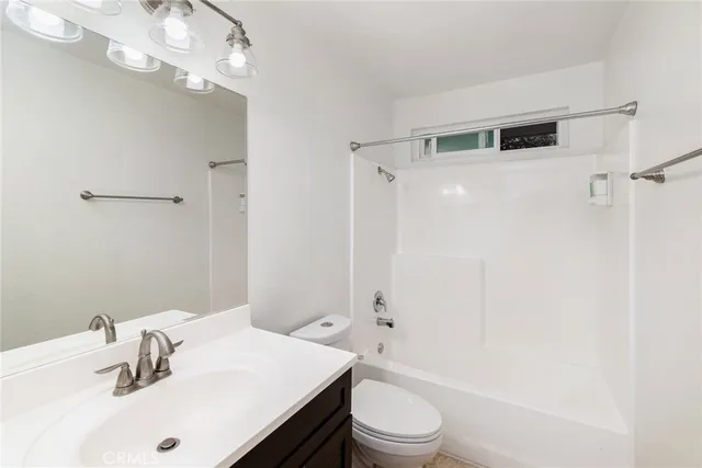 a bathroom with a sink a toilet a mirror and shower