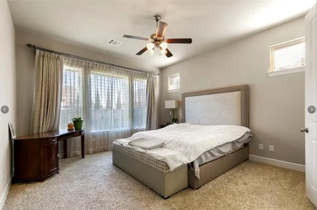 a bedroom with a bed and large window