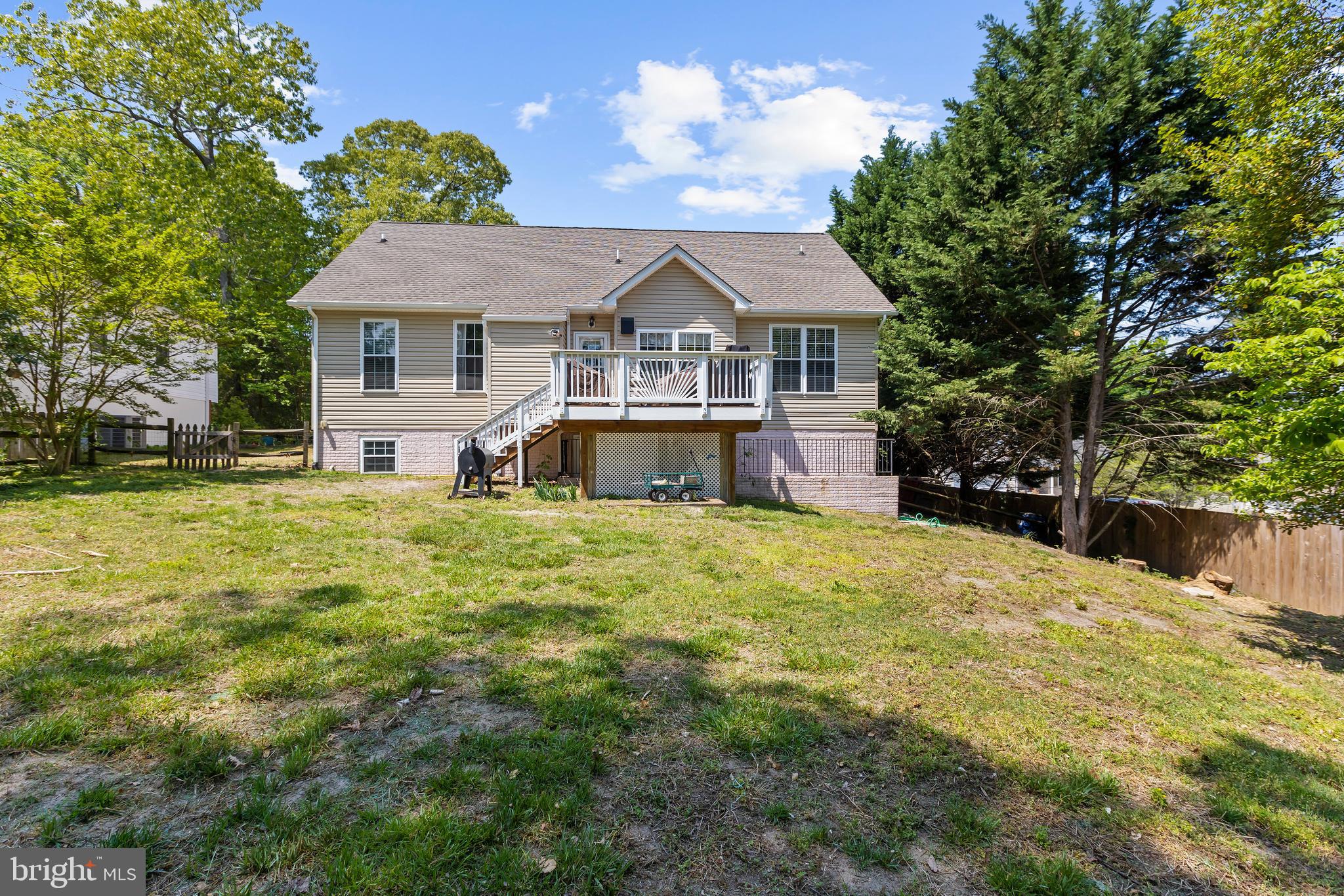 11312 Rawhide Road Lusby, MD 20657 - Photo 8 of 57 a view of a house with a big yard and large trees