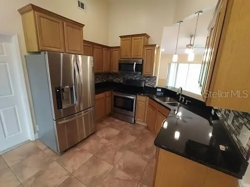 a kitchen with stainless steel appliances granite countertop a refrigerator and a stove