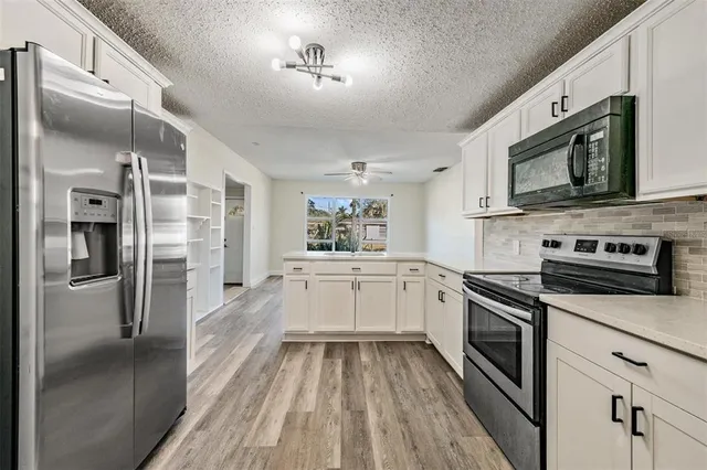 a kitchen with a refrigerator stove and microwave