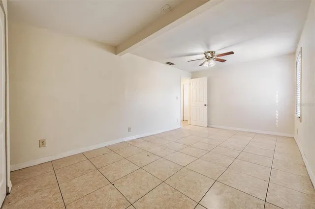 a view of an empty room with a chandelier fan