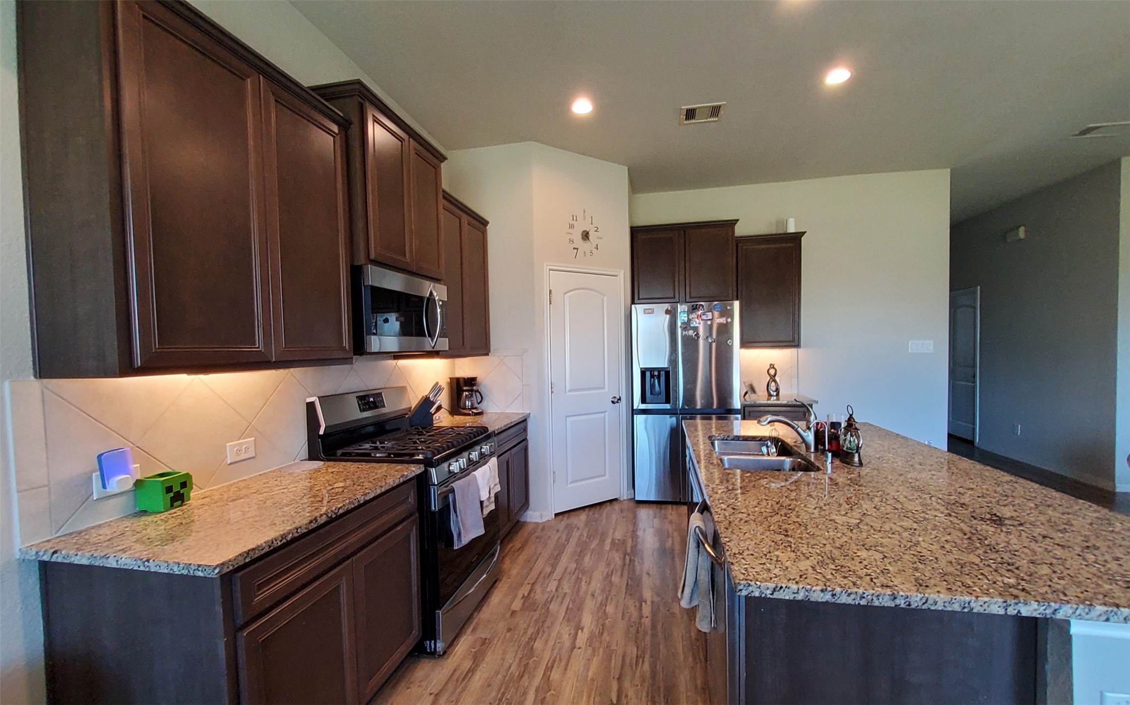 24418 Hollow Gate Meadow Court Spring, TX 77389 - Photo 15 of 45 a kitchen with kitchen island granite countertop a sink stove and refrigerator