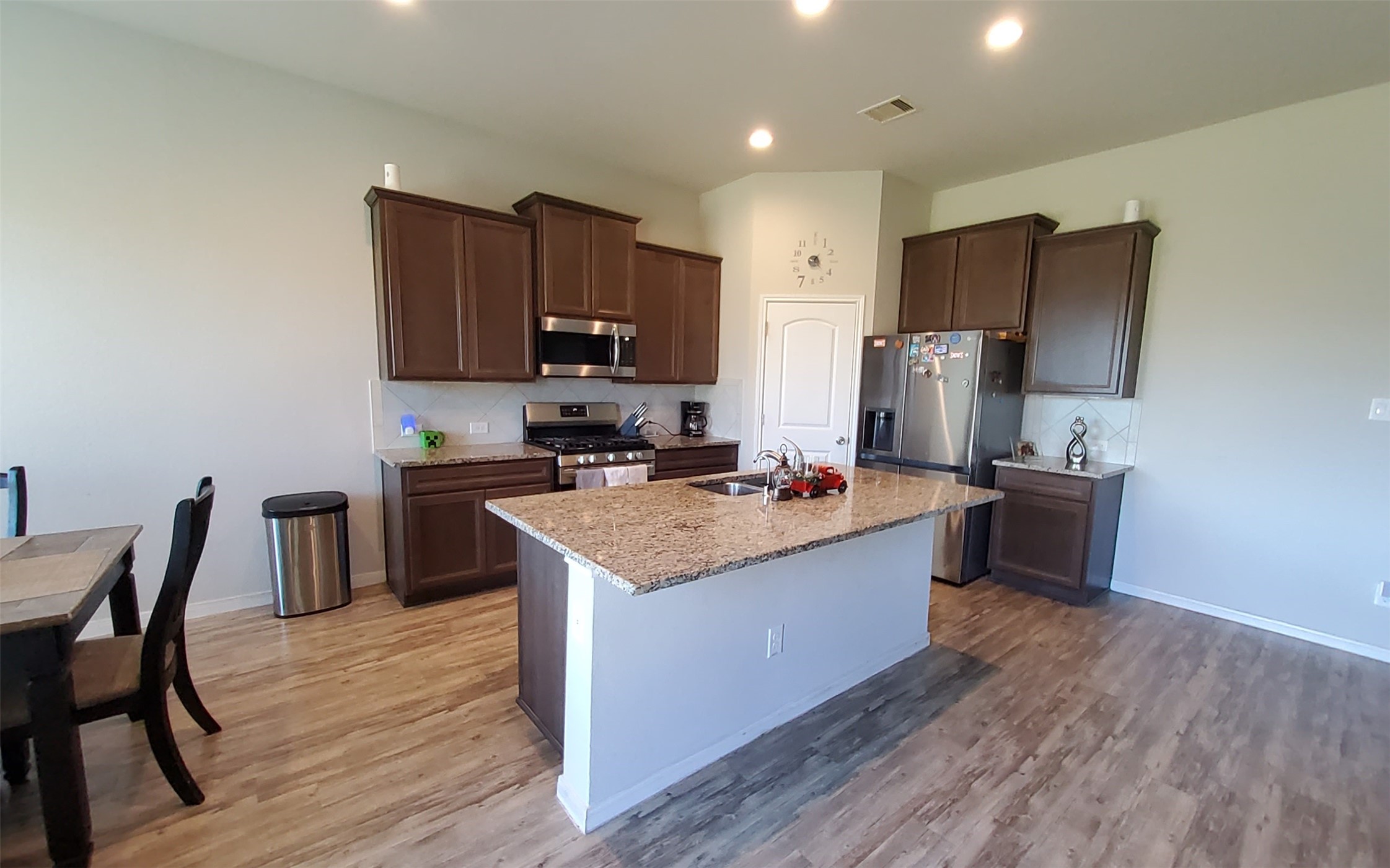 24418 Hollow Gate Meadow Court Spring, TX 77389 - Photo 21 of 45 a kitchen with kitchen island granite countertop wooden floors stainless steel appliances and a sink