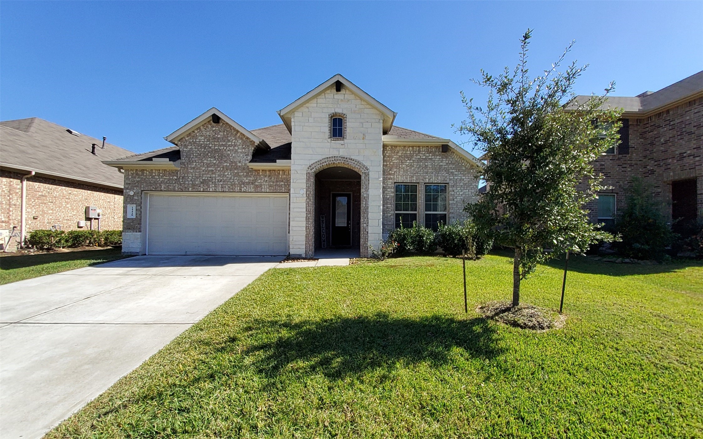 24418 Hollow Gate Meadow Court Spring, TX 77389 - Photo 4 of 45 a front view of a house with a yard and garage