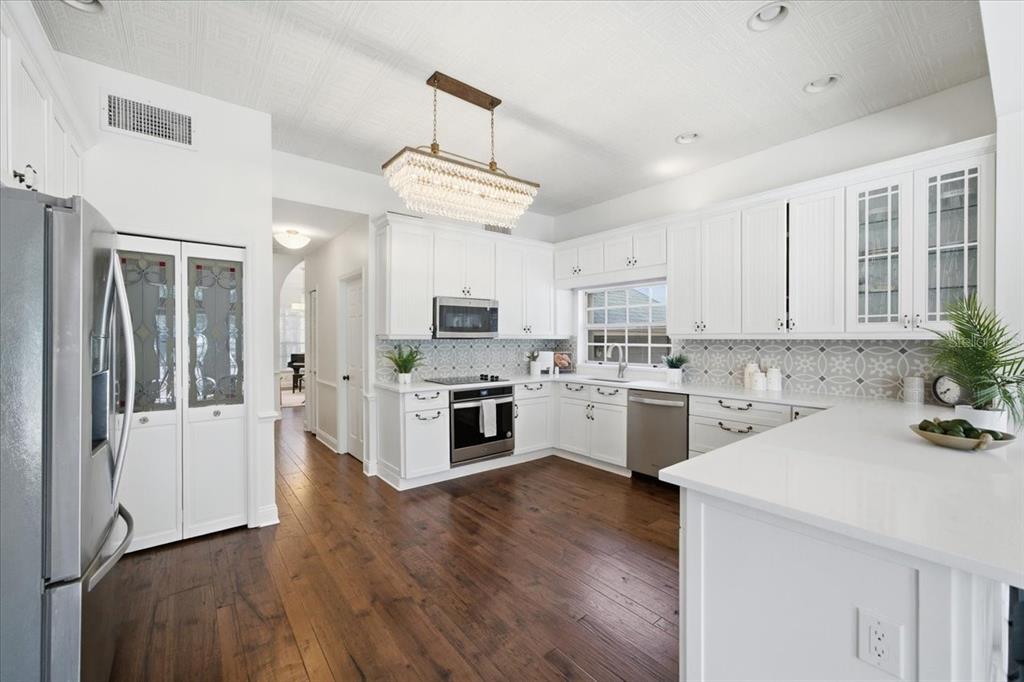 3049 Geiger Court Clearwater, FL 33761 - Photo 32 of 90 a kitchen with white cabinets and stainless steel appliances