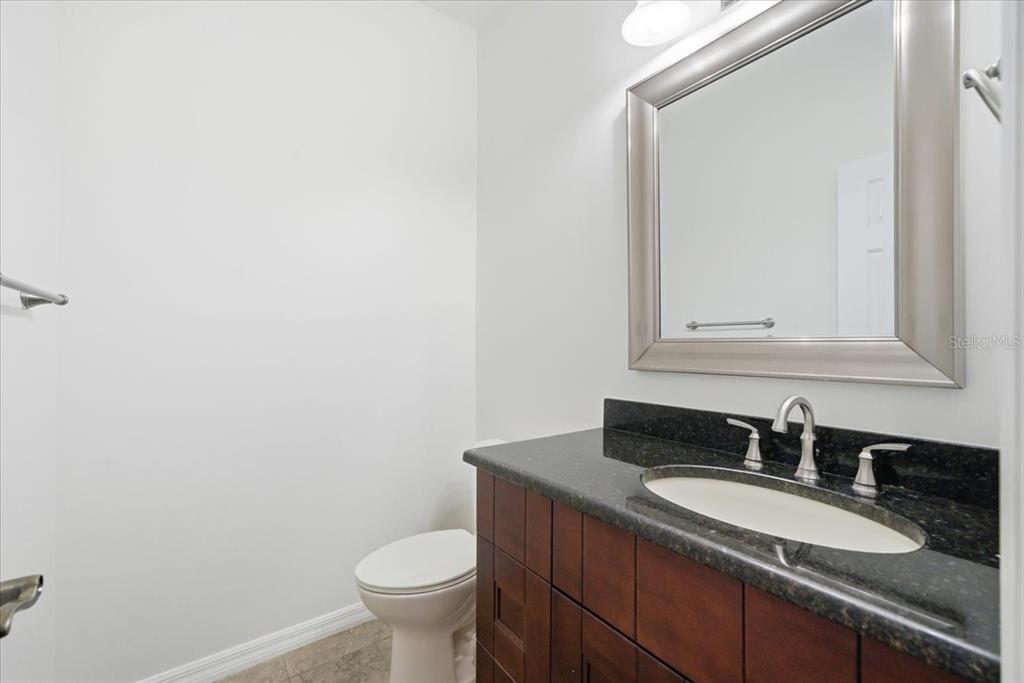 3049 Geiger Court Clearwater, FL 33761 - Photo 40 of 90 a bathroom with a granite countertop sink toilet and mirror