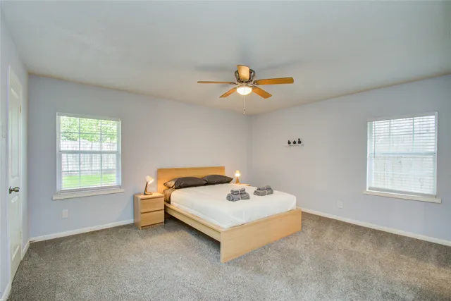 a white bed sitting in a bedroom next to a window