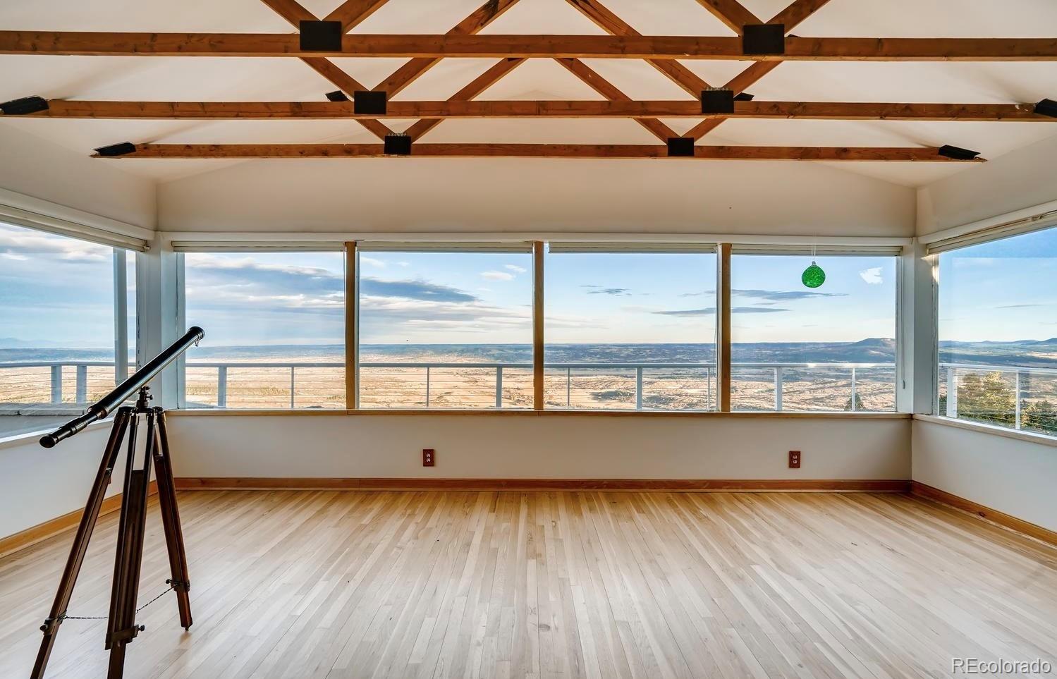 1150 North Madge Gulch Road Sedalia, CO 80135 - Photo 18 of 49 a view of an empty room with wooden floor and a window