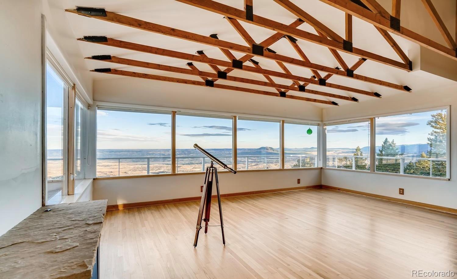 1150 North Madge Gulch Road Sedalia, CO 80135 - Photo 20 of 49 a view of an empty room with wooden floor and a window